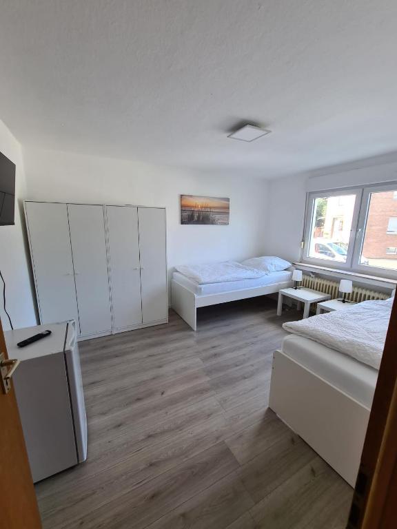 ein weißes Zimmer mit 2 Betten und einem Tisch in der Unterkunft Monteurunterkunft mit Terrasse in Lünen in Lünen