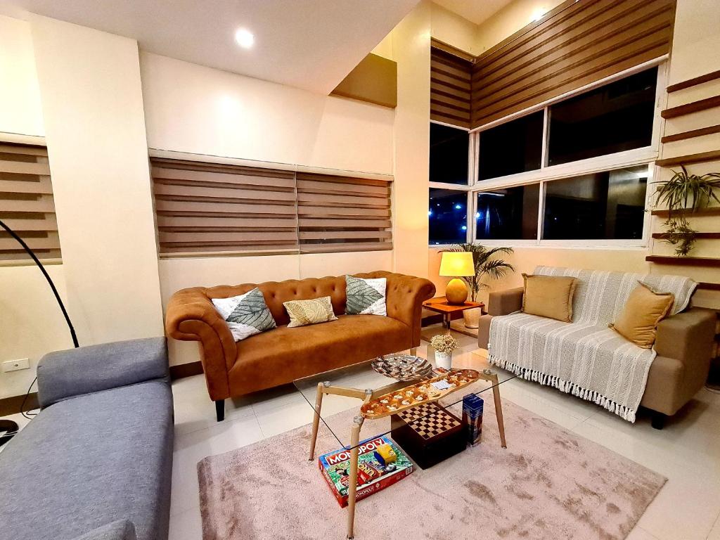 Serenity Home near Ayala Malls Serin في تاجيتاي: غرفة معيشة مع أريكة وطاولة