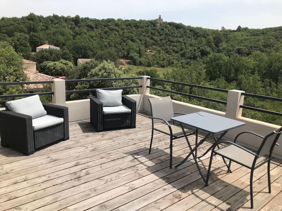 een terras met stoelen en een tafel bij Studio au calme, grande terrasse avec vue vallée in Ginasservis