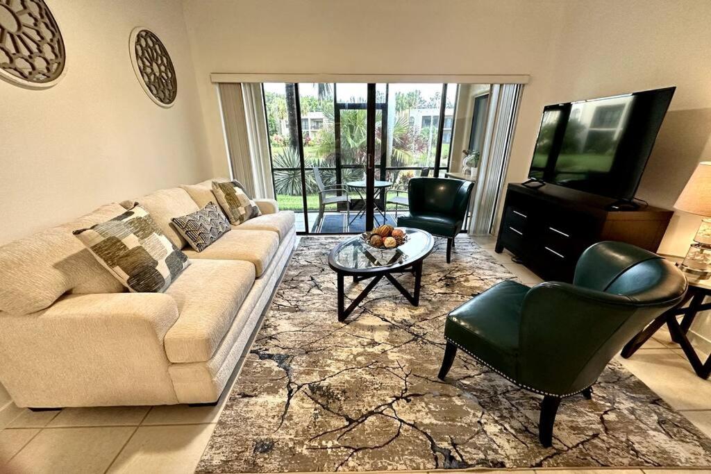 a living room with a couch and a table and a television at Awesome Apartment near the Beach in Naples