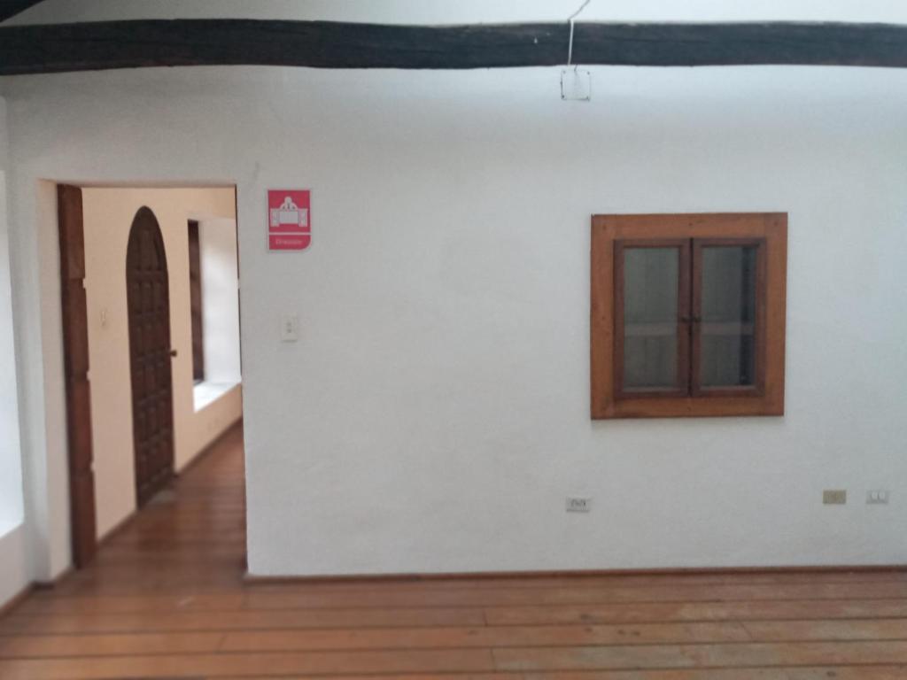 Zimmer mit einer weißen Wand und einem Fenster in der Unterkunft Quinta los Eucaliptos in Quito