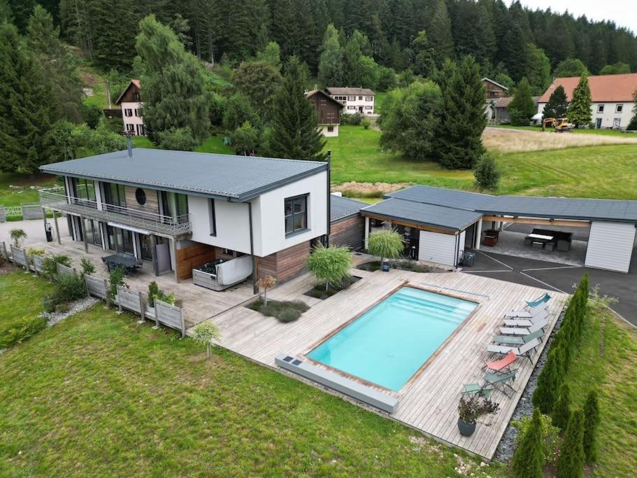 eine Luftansicht eines Hauses mit Pool in der Unterkunft Villa 4 Saisons, avec piscine chauffée et jacuzzi in Gérardmer