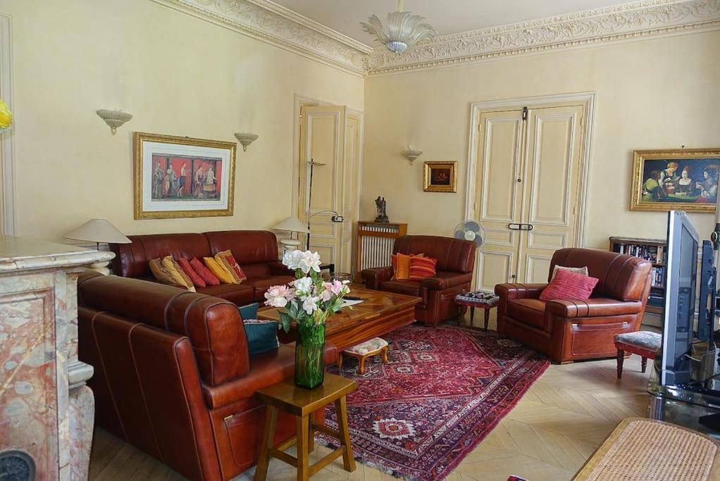 a living room with leather furniture and a vase of flowers at Monceau/Villiers : Magnifique appartement 6P in Paris