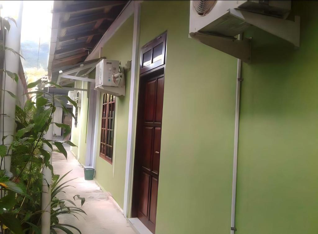 um corredor de uma casa com uma porta de madeira em Penginapan Asri Guest house 