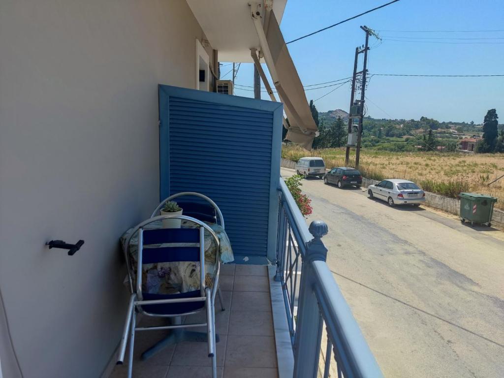 une chaise sur un balcon avec un volet bleu dans l'établissement Superb studio in Lixouri, à Lixouri