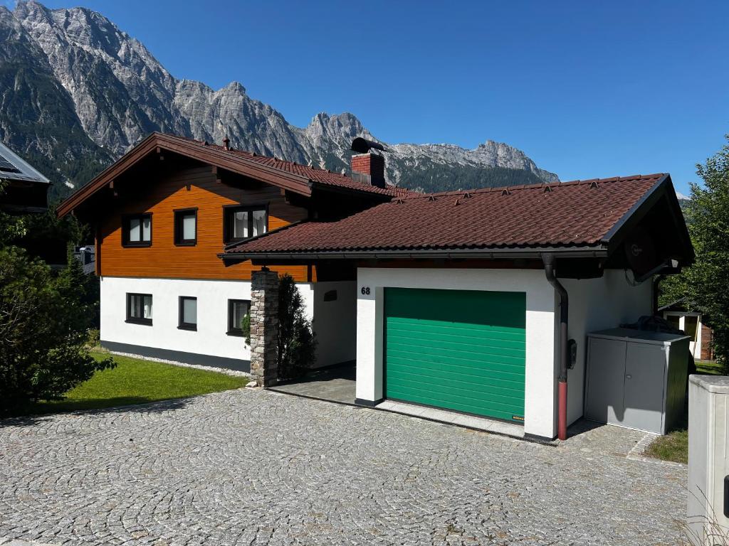 a garage with a green garage door in front of a house at Ferienhaus Hochkönigblick in Leogang