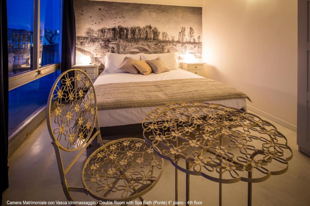 sypialnia z łóżkiem i 2 krzesłami przed łóżkiem w obiekcie B&B 52cento w Arezzo