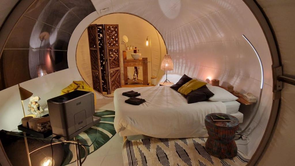 a bedroom with a bed in a round room at Ecolieu BnBubble Drincham by BubbleTree BBT SARL in Drincham