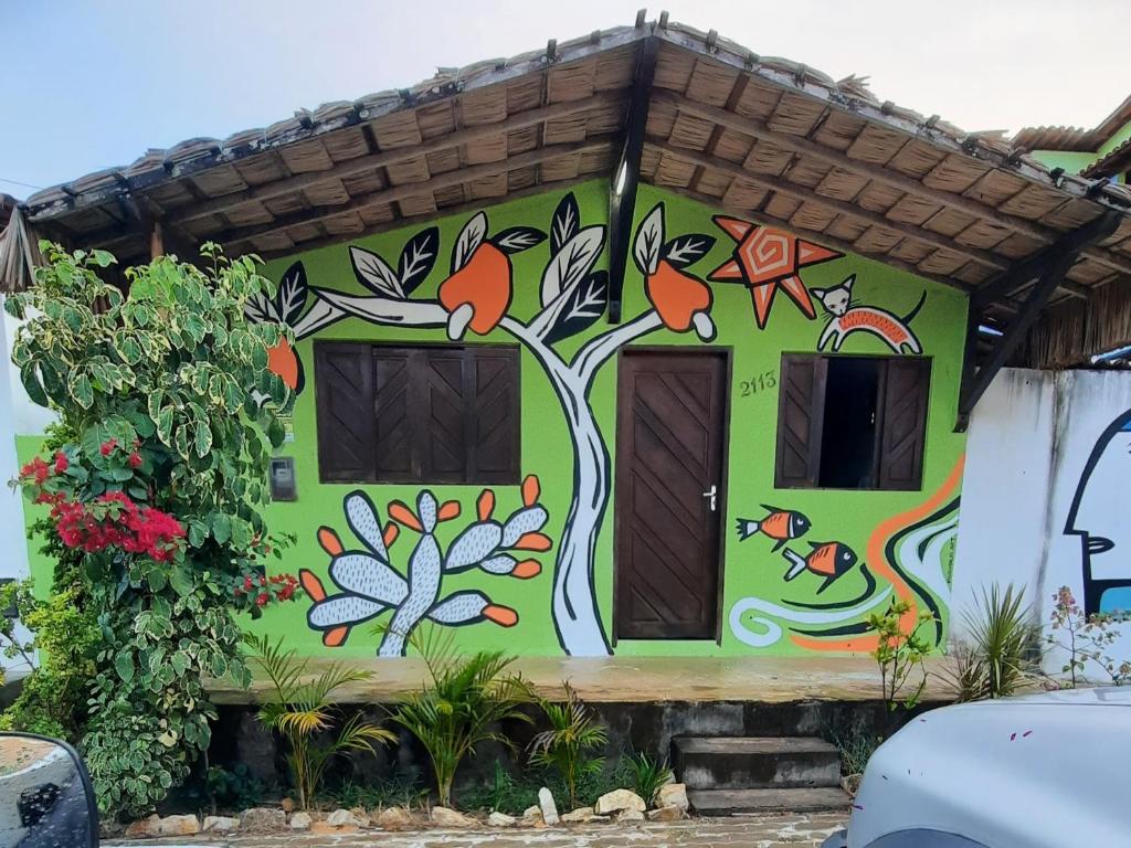 a house with a tree painted on it at Espaço HaRo in São Miguel do Gostoso