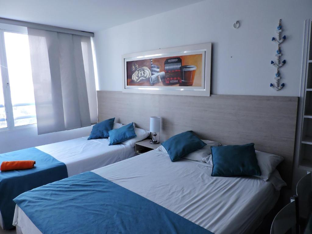 deux lits dans une chambre avec du bleu et du blanc dans l'établissement Estudio Loft Cartagena, à Carthagène des Indes