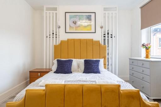 a bedroom with a large yellow bed with blue pillows at Walsgrave Road Apartment - 5 Beds - Free Parking & Wi-Fi in Wyken