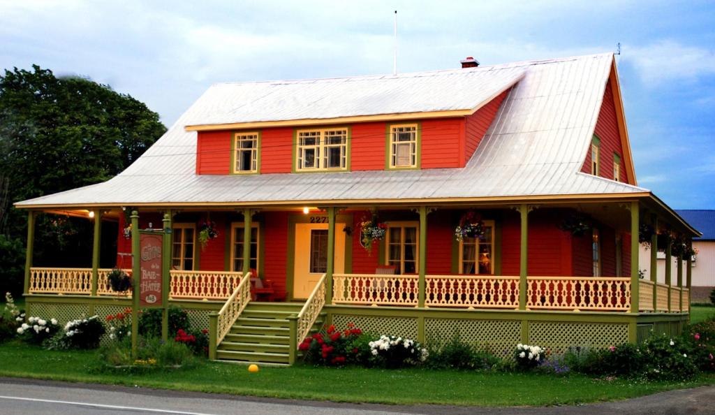 a red house with a white roof at Gite de la Baie Hatée in Bic