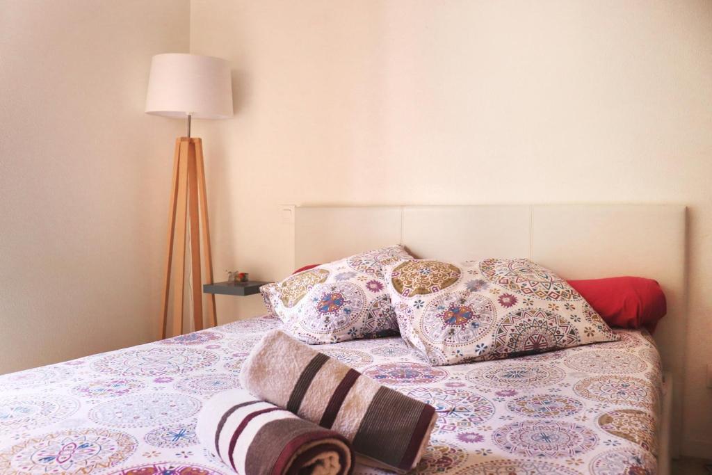 a bedroom with a bed with pillows and a lamp at Le Chapitre Spacieux - parking en résidence fermée in Toulouse