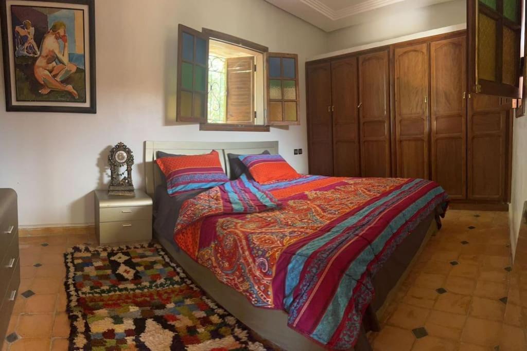 a bedroom with a bed with a colorful comforter and a rug at dream farm in Marrakesh