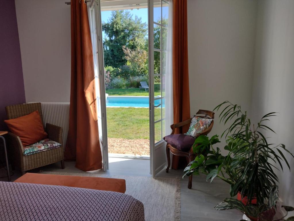 ein Wohnzimmer mit einer Tür zum Pool in der Unterkunft Le Chêne Olivet in Olivet