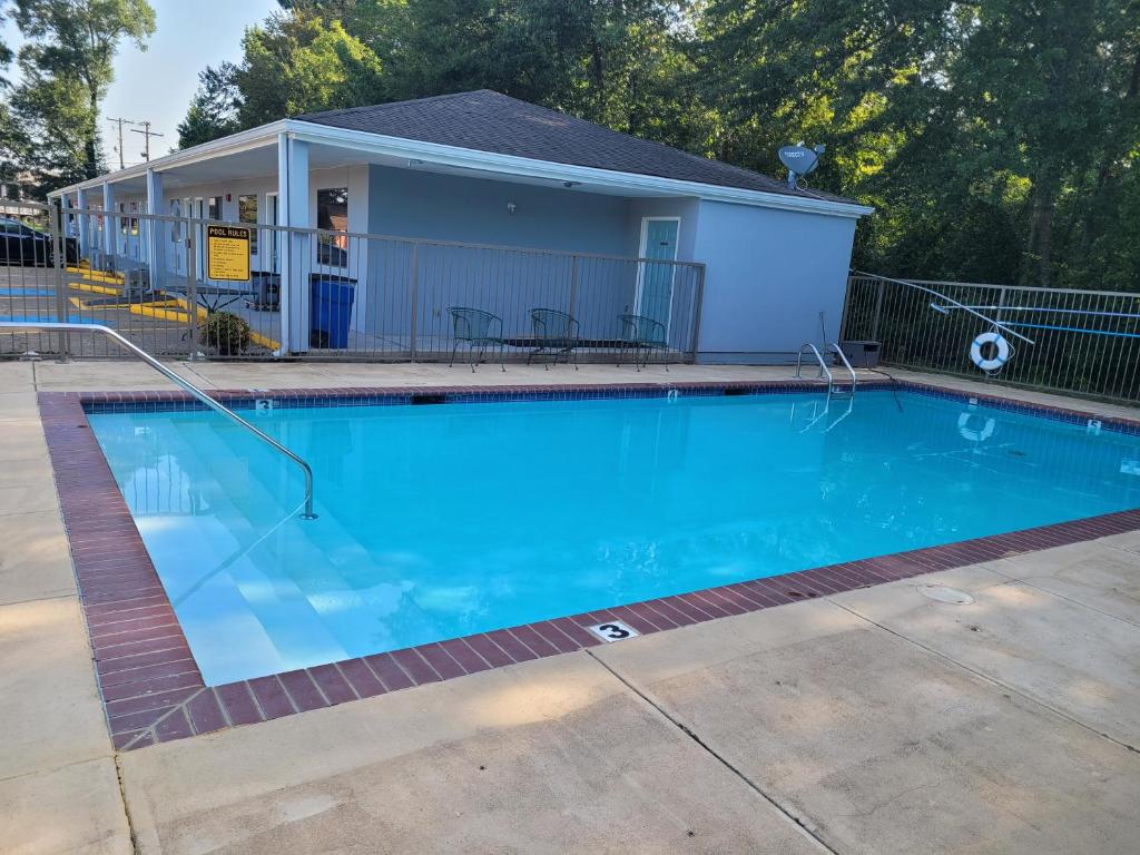 a swimming pool in front of a house at Super 8 by Wyndham Arkadelphia Caddo Valley Area in Arkadelphia