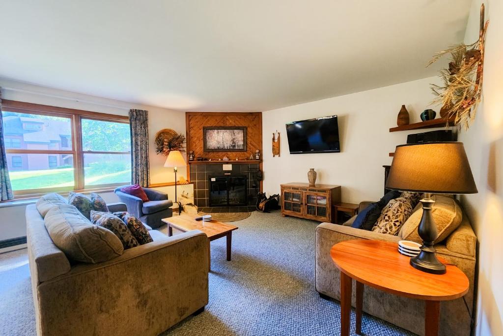 uma sala de estar com um sofá e uma mesa em Trail Creek 41 em Killington