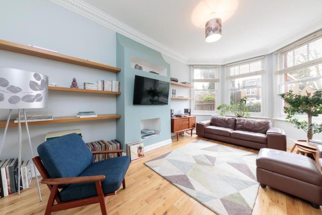 a living room with a couch and a tv at Bright & spacious modern 2 bedroom apartment in London