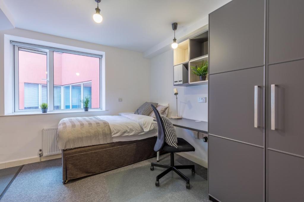 a bedroom with a bed and a desk and a window at Studio Flat Farringdon in London