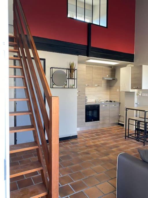 un salon avec un escalier et une cuisine dans l'établissement Studio duplex meublé avec place de parking, à Surgères