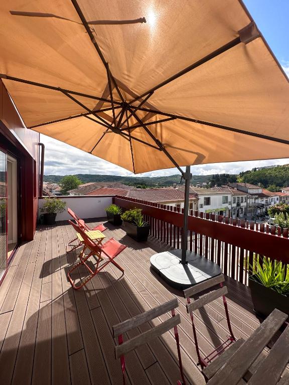 a patio with chairs and an umbrella on a deck at Casa Sousa 3rd generation - Apart 1 in Boticas