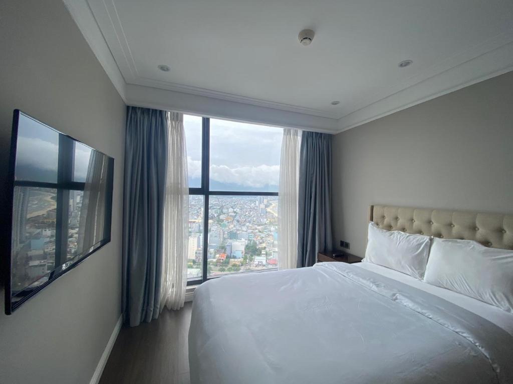 a bedroom with a large bed and a large window at Luxury Apartment in Da Nang