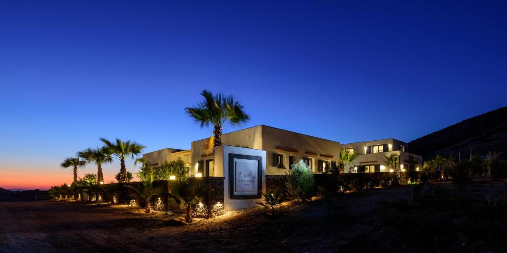 a house with palm trees in front of it at night at White Dream Suites Antiparos in Antiparos