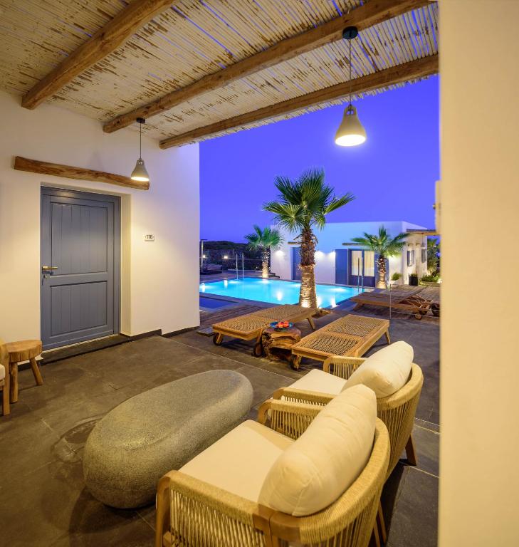 a patio with chairs and a swimming pool at night at White Dream Suites Antiparos in Antiparos