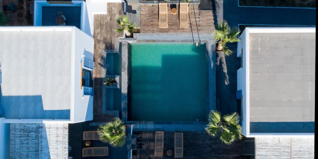 an overhead view of a swimming pool with palm trees at White Dream Suites Antiparos in Antiparos