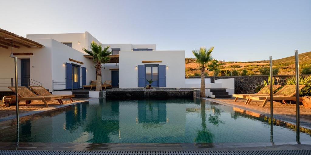 a swimming pool in front of a villa at White Dream Suites Antiparos in Antiparos