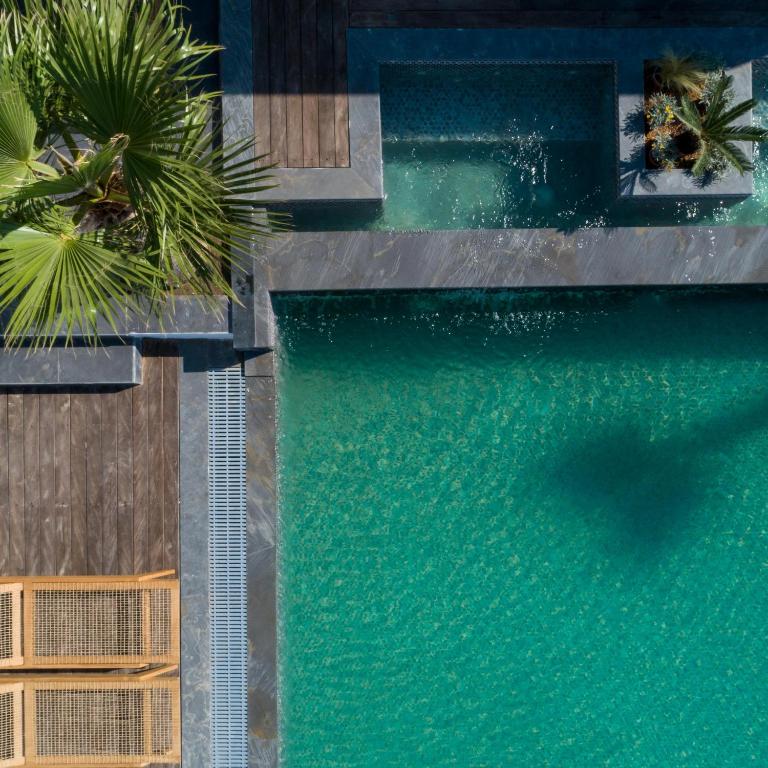 an overhead view of a swimming pool with palm trees at White Dream Suites Antiparos in Antiparos
