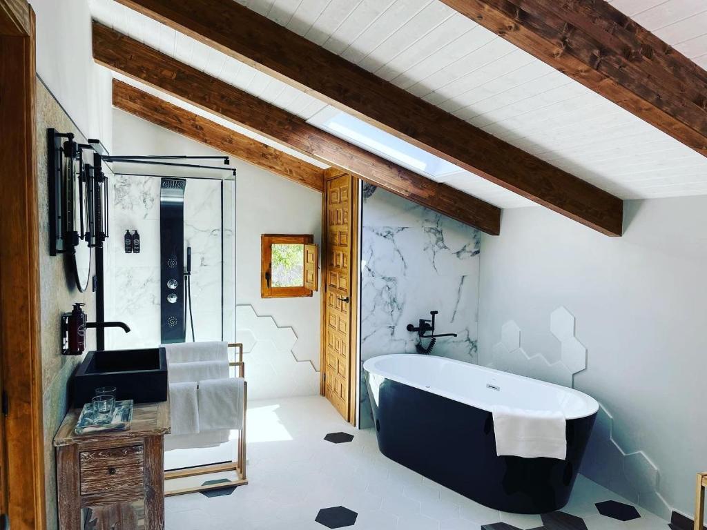 ein Badezimmer mit einer großen Badewanne und einem Waschbecken in der Unterkunft El Refugio de Haro in Haro