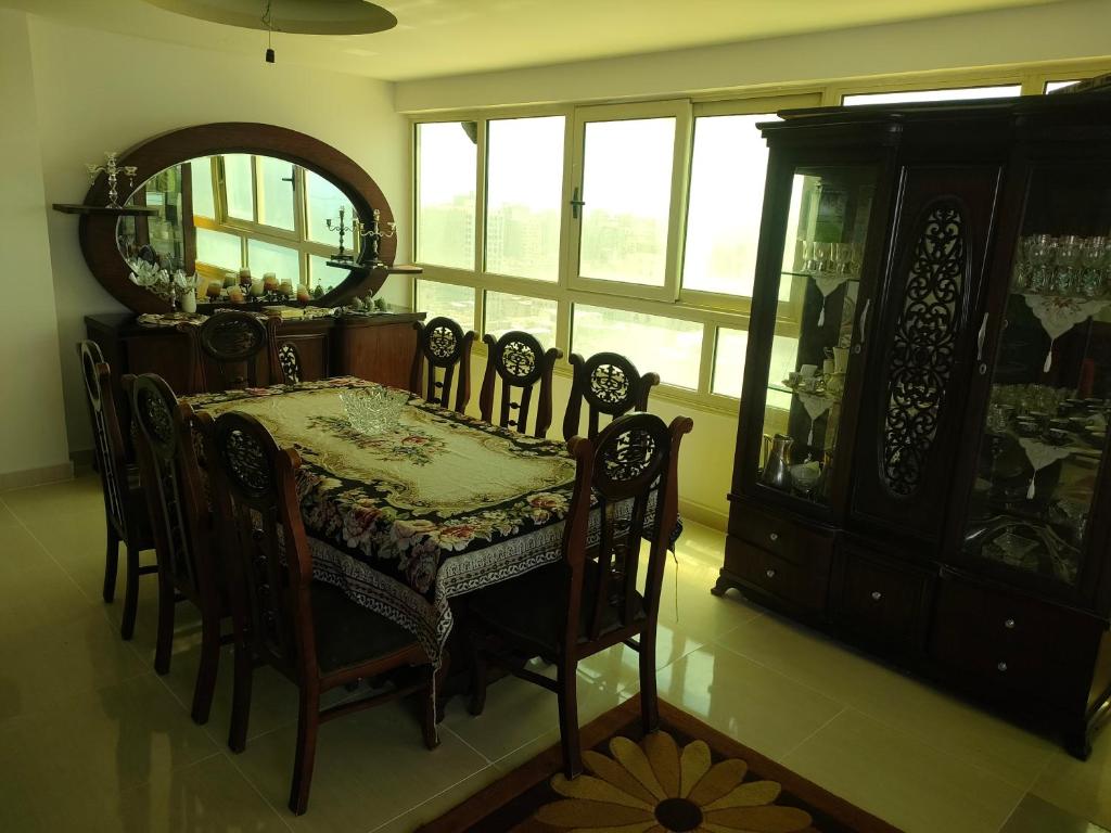 a dining room with a table and chairs and a mirror at شقه فاخره للايجار المفروش الابراهيميه على البحر in Alexandria