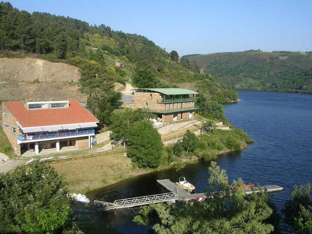 a house on an island in the middle of a river at COMPLEXO TURISTICO PONTE MOURULLE in Insúa