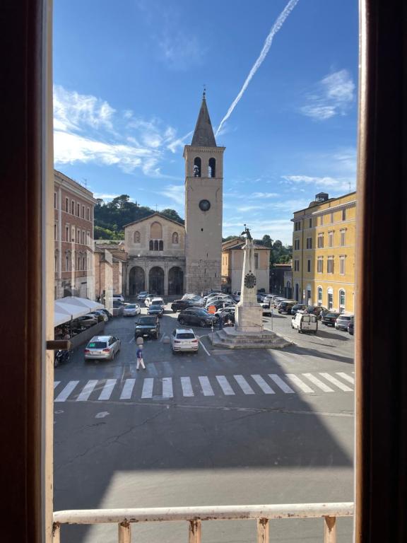 einen Blick aus dem Fenster einer Stadt mit einem Uhrturm in der Unterkunft Appartamento in Piazza Spolethome in Spoleto