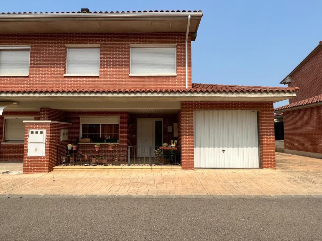 a brick house with two garage doors on a street at Casa grande con gran jardín privado in Quicena