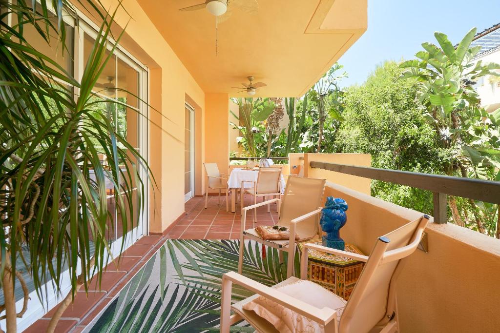 balkon domu z krzesłami i stołem w obiekcie Beach & Golf Design Apartment Marbella w Marbelli