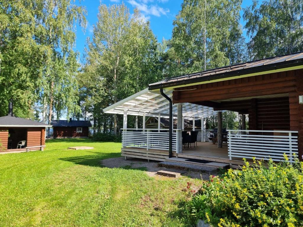 eine Holzhütte mit einer Terrasse im Hof in der Unterkunft Holiday Home Saarenpää by Interhome in Koivisto