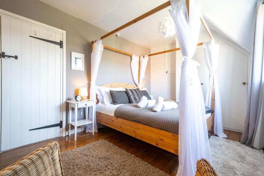 a bedroom with a bed with a canopy at Fairstead Cottage in Holt