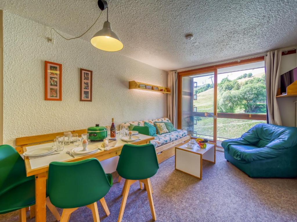 een woonkamer met een tafel en groene stoelen bij Apartment Pegase Phenix-39 by Interhome in Le Corbier