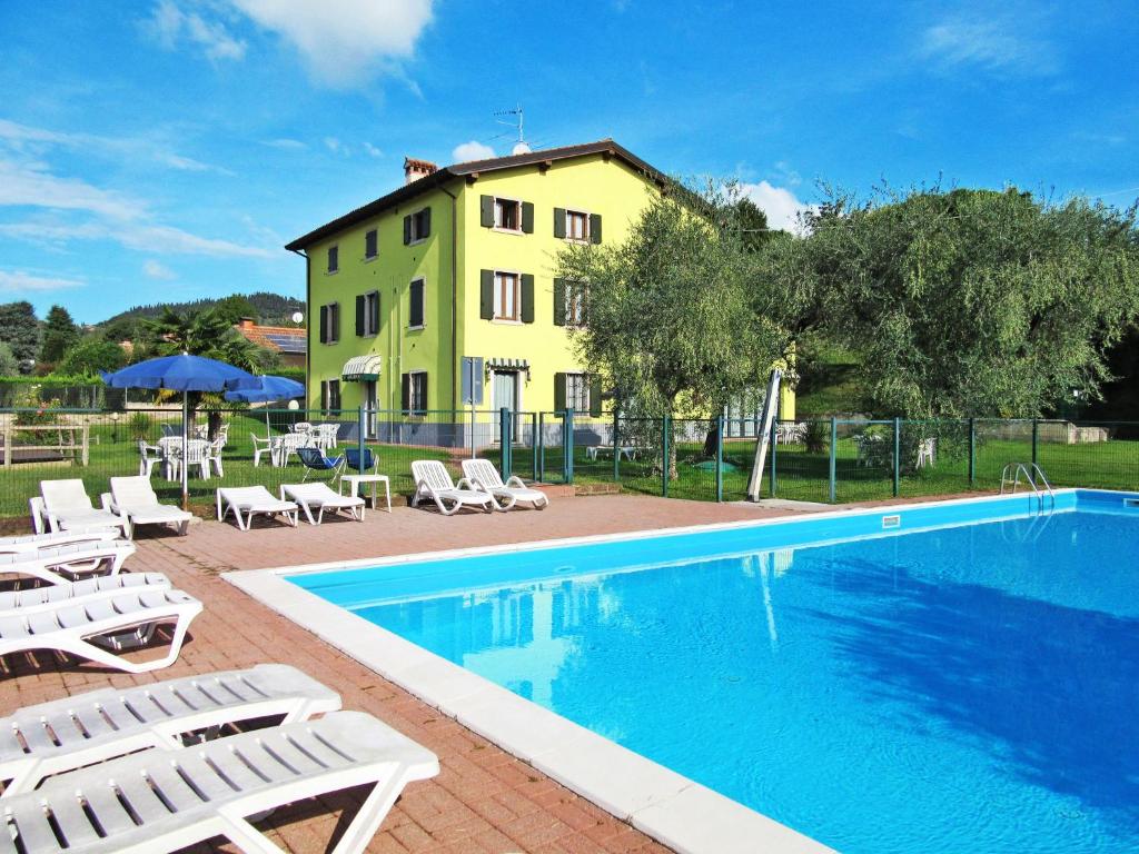 a pool with chairs and a building in the background at Apartment Ca' Bottrigo-2 by Interhome in Bardolino