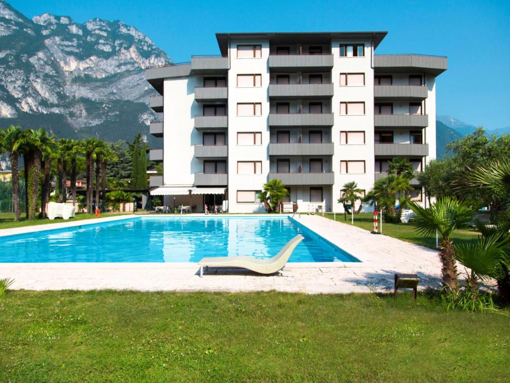 a hotel with a swimming pool in front of a building at Apartment Comfort by Interhome in Riva del Garda