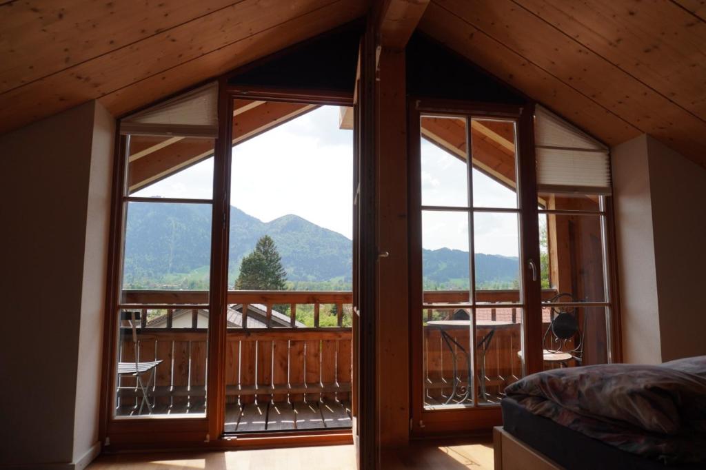 a bedroom with a view of the mountains from the balcony at Ferienwohnung Bergblick im Tiefenweg 15A in Lenggries