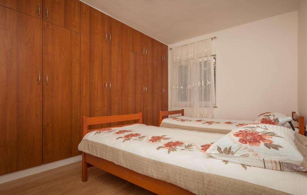 a bedroom with two beds and wooden cabinets at Apartment Juliette in Zadar