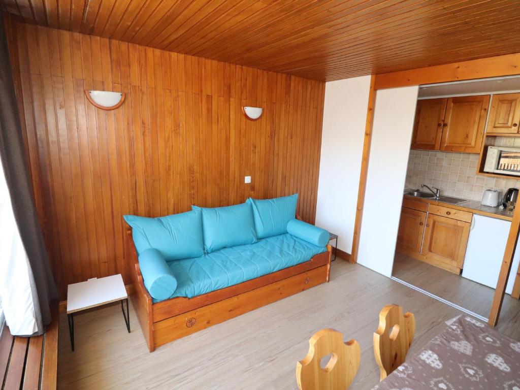 niebieską kanapę w pokoju z kuchnią w obiekcie Appartement lumineux Proche des commerces et des pistes Balcon - FR-1-502-483 w mieście Tignes
