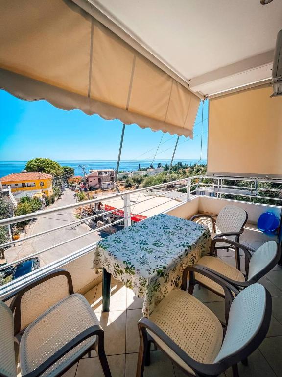 a table and chairs on a balcony with a view of the ocean at Monda Apartments Dhermi in Dhërmi