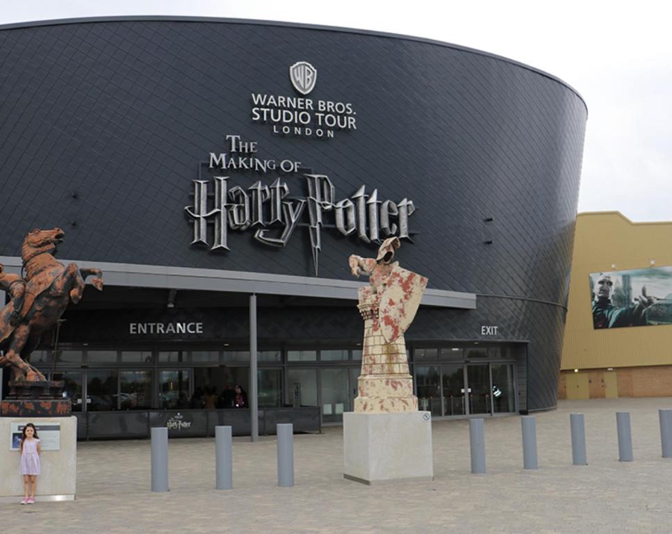 a large building with a statue in front of it at Warner Brothers House in Watford