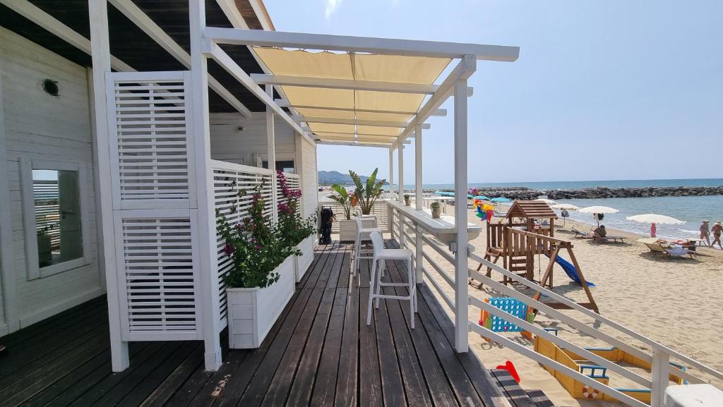 a wooden deck with tables and chairs on the beach at LA VILLA fronte SPIAGGIA BANDIERA BLU in Sperlonga