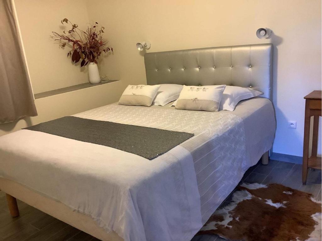 ein Schlafzimmer mit einem großen Bett mit weißer Bettwäsche in der Unterkunft GITE CHOUCHOU in Izé