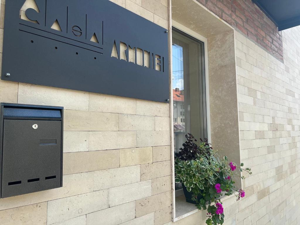 a sign on the side of a building with a plant at Casa Armoniei in Baia Mare